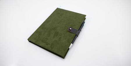 Notebook green velvet with a black pen.の写真素材