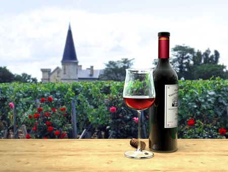A bottle and a glass of fictitious Bordeaux red wine with a château in the background A bottle and a glass of fictitious Bordeaux red wine with a château in the background