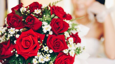 Red roses bouquet on the table with the brideの写真素材