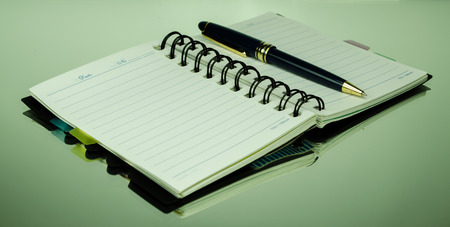 Pen and notebook on glassの写真素材