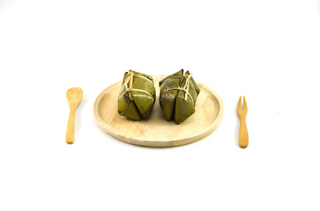 Thai traditional sticky rice dessert in banana leaf packaging.の写真素材