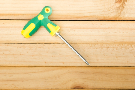 Yellow  screwdriver on wood background. twistの写真素材
