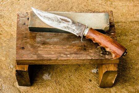 Whetstone and knife. on wood