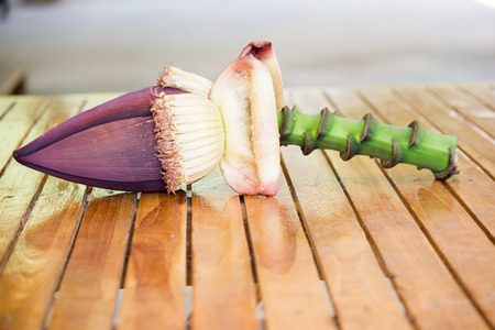 Banana blossoms on brown wood floor.の写真素材