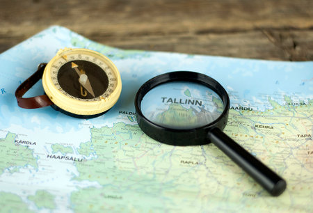 Compass and magnifying glass on the map Estonia. Authentic and rustic lens and compass. Selective focus. Blurred vision. Tallinn city.のeditorial素材