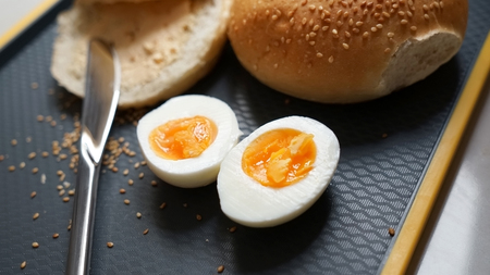 Bun with soft chees and boiled eggs on a chopping board. Sesame seeds. Concept is quick snak.の写真素材