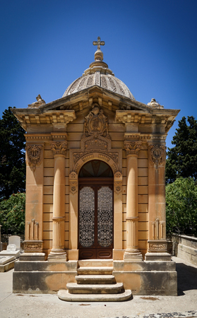 The old single family crypt on a blue sky background. Santa Marija Addolorata cemetery. Paola. Malta.の写真素材