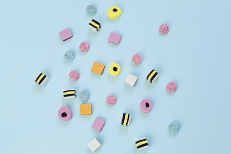 Colored candy scattered on the blue backgroundの写真素材