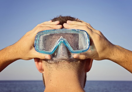 A man in a diving mask stands behind. Summer leisure conceptの写真素材