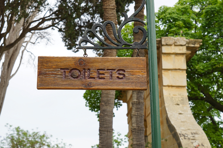 Sign of toilet written on a wooden board. Mark public toilet in the park, selective focusの写真素材