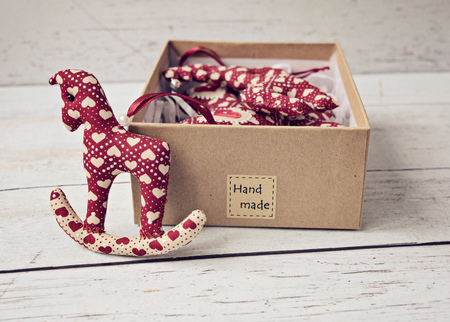 Christmas handmade decorations soft toys in gift box on the white background, close up horseの写真素材