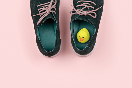 Abstract pastel color Men's shoes with yellow duck on pink. Pranks and tricks concept for April fool's dayの写真素材