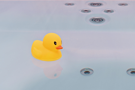 Large yellow rubber duck floating in bathtub. Bath time conceptの写真素材