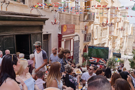 VALLETTA, MALTA - JUNE 24, 2018: Maltese people fans watch football match on Valletta street in capital of Malta in sports pub outsideのeditorial素材
