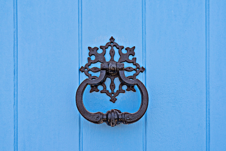 Closeup of traditional maltese door beater on blue wooden door. Vintage Forged carved knockerの写真素材