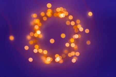 Blurred defocused magic fairy light glitter by Christmas lights on dark blue background, shallow DOFの写真素材