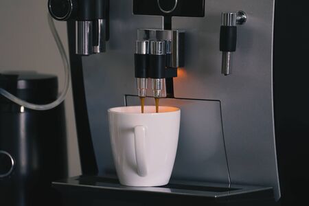 Closeup espresso coffee machine. Automatic coffee maker with cup of cappuccino domestic household appliancesの写真素材