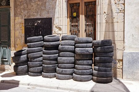 Pile of used car rubber tires near auto garage on street. Tyre fitting serviceの写真素材