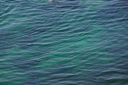 Closeup view of texture of aquamarine sea surface with small ripples of waves, background