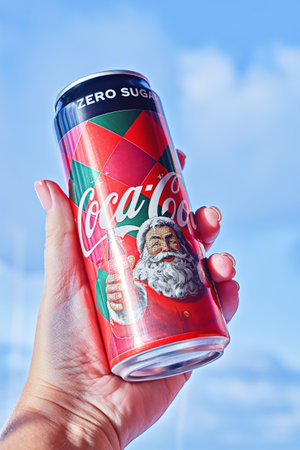 Limited edition Coca-Cola packaging during Christmas in hand against blue sky: Tallinn, Estonia - 2...