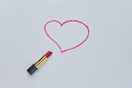 Red heart drawing by red lipstick on white. Sketch closeup on white backdrop. Valentines day romantic background. Simple shape.の写真素材