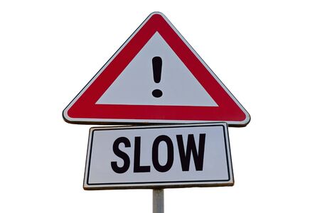 Red and white attention warning road sign "SLOW" against blue sky. Speed Limit sign on the road. Traffic signs concept, low angle viewの写真素材