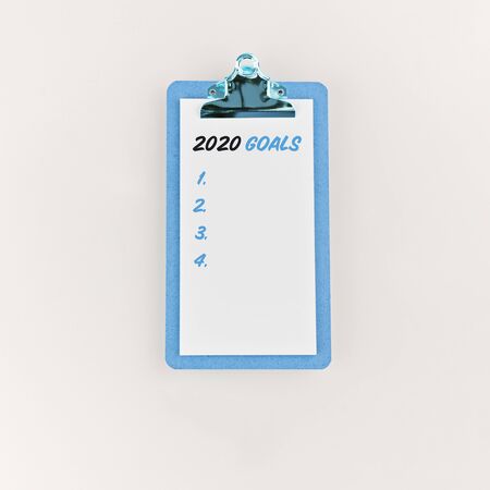 Goals 2020 on clipboard with on white background. Minimal style clipboard with wish to do list on white background, flat lay style. Planning and resolution conceptの写真素材
