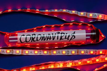 Abstract lab tube with tag coronavirus in secret laboratory with red led-light. Novel coronavirus 2019-nCoV on blue backgroundの写真素材