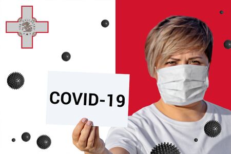 Woman in face mask hold sheet with inscription COVID-19 against Maltese flag. Concept of attention about spread of Coronavirus COVID-19 Novel Coronavirus Pneumonia virus around worldの写真素材