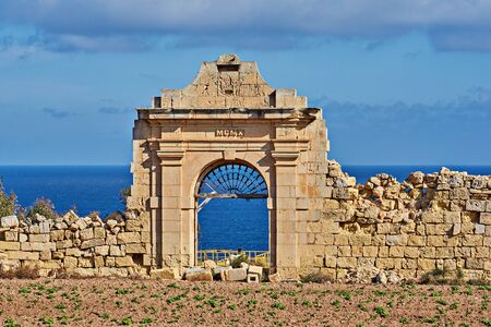 View of ruined ancient gate to villa dates from 1910 against blue sea and skyの写真素材