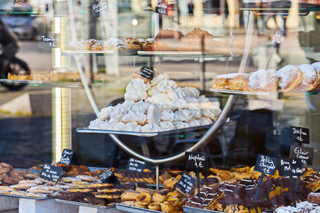 Showcase of cozy bakery with variety of pastries, cookies and pies. Inscription in Portuguese: eclair, cake, chocolate, meringue, bunの写真素材