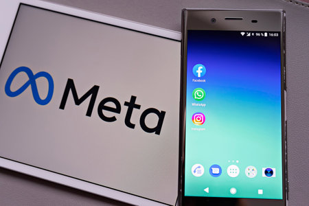 Smartphone display with logo of Facebook, WhatsApp and Instagram apps in against blurred META...