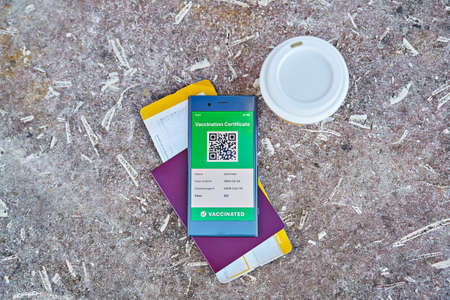 Smartphone displaying valid digital vaccination certificate QR Code for COVID-19, flat lay. Vaccination and health passport, international travel health controlの写真素材