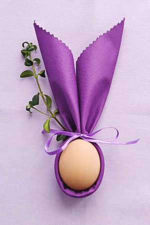 Decorative Bunny Ears with egg on purple cotton tablecloth to Celebrate Easter