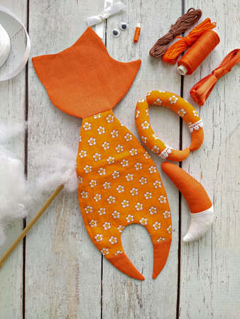 Process of stuffing soft toy red textile fox by handmade, top view and sewing accessoriesの写真素材