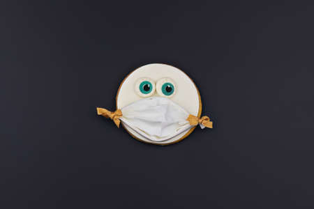Spooky funny handmade cookie face with big eyeballs on black background