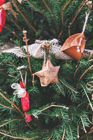 Vintage wooden star and leather toy on Christmas tree. Natural DIY ornaments for Christmas tree,...