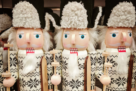 Row of white nutcracker soldiers with skis and fur hats, wooden holiday figurines on shelf, bright...