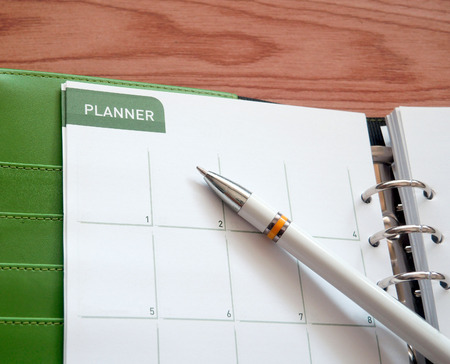 Personal organizer or planner with pen on wooden table. Remind Conceptの写真素材