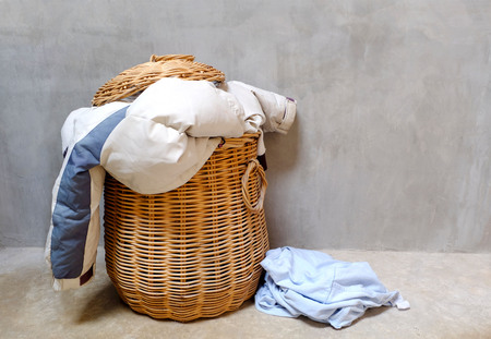 Overflowing wicker laundry basket. Household chore concept.の写真素材