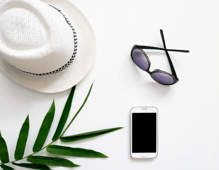Summer accessories and travel items hat, sunglasses, smart phone on white backgroundの写真素材