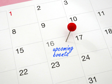 Upcoming events written on calendar with red thumbtacks as a concept of events.の写真素材
