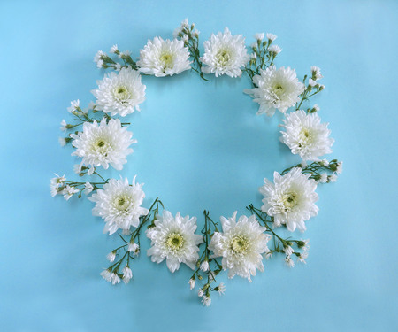 Flower composition round frame wreath made of white flowers on blue background.  Flat lay, top viewの写真素材
