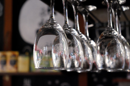Glasses of wine hanging above a bar rack in restaurant.の写真素材