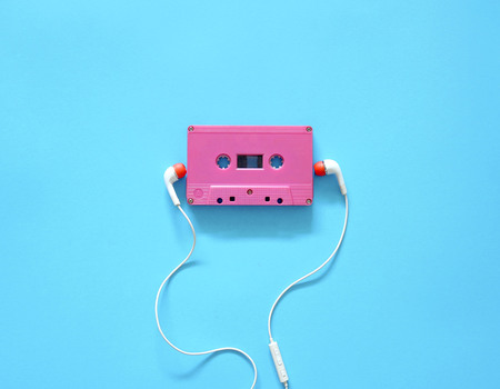 Audio cassette and earphones on a blue background. Musical concept. Minimal style.の写真素材