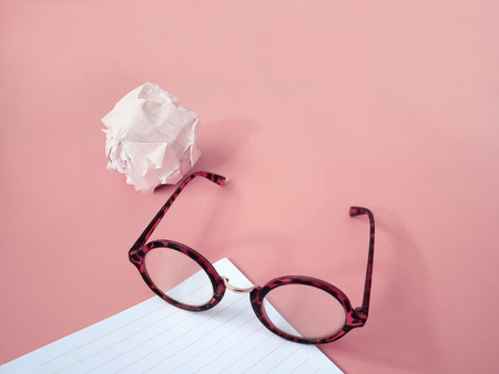 Crumpled paper and eyeglasses with copy space on pink background.Business strategy concept.の写真素材