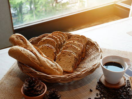 Breakfast with whole grain bread  and black coffee on table.の写真素材