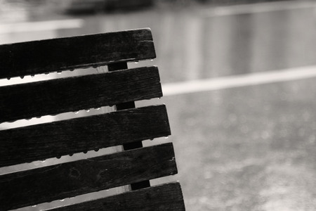 Raindrops on bench on a rainy day. Concept of lonely, sad, alone.の写真素材
