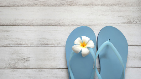 Beach slippers and flower on wooden background, summer holiday concept.の写真素材