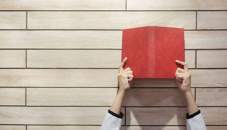The hand holding book on wooden background with copy space.の写真素材